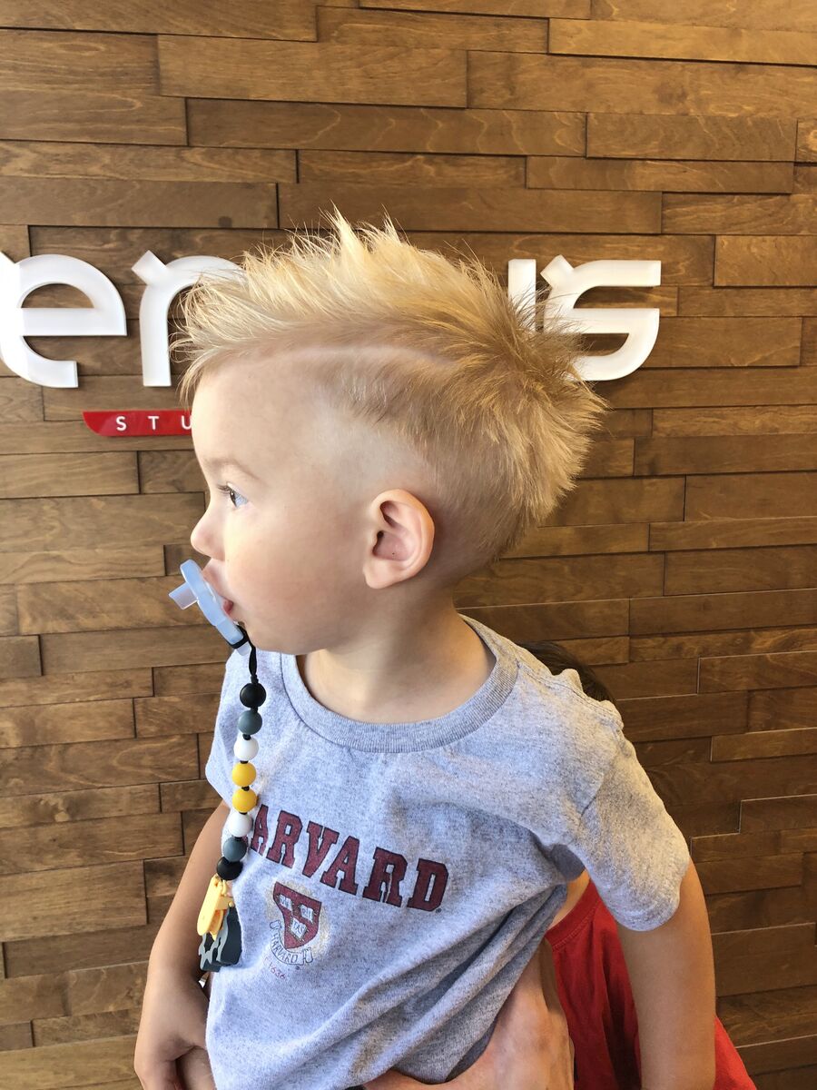 Boy's haircut with a short fade and a spiky top