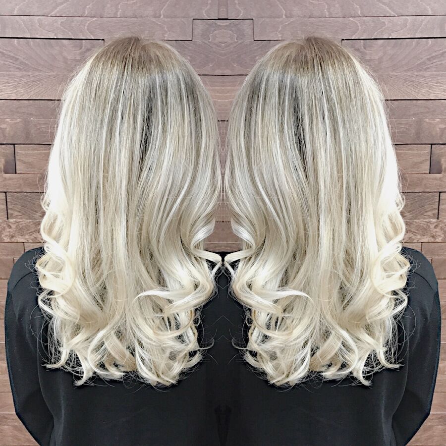 Icy blonde highlights on long curls, seen from the back